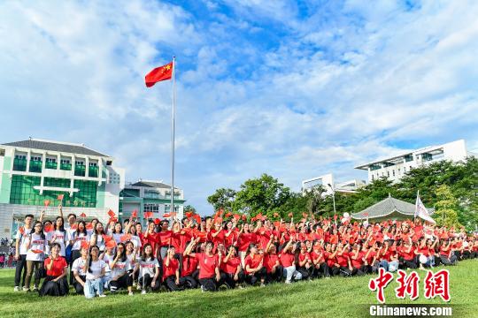 9月2日，广州中医药大学，学生们在入学升国旗仪式结束后与国旗合影。　陈骥旻 摄
