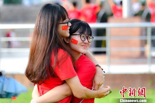 9月2日，广州中医药大学，两名学生在入学升国旗仪式结束后拥抱合影。　陈骥旻 摄